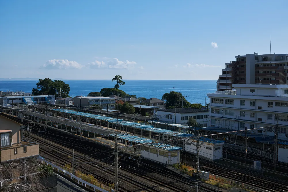 左側に国府津駅の駅舎があり、その先には海が広がっている